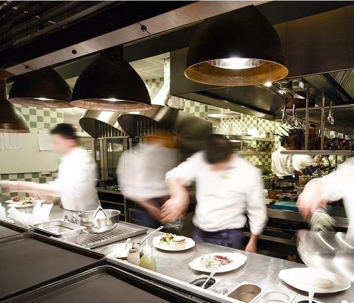 restaurant kitchen; workers plating food